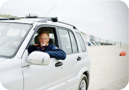 Ruud in zijn auto waarmee hij dagelijks over het strand rijdt.
